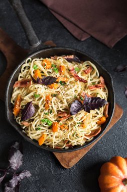 Kabak ve dökme demir tavada pastırma ile sonbahar makarna. Ev yapımı spagetti kabak pasta siyah, kopya alanı. Sonbahar gıda.