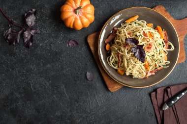 Kabak ve plaka üzerinde pastırma ile sonbahar makarna. Ev yapımı spagetti kabak pasta pastırma, parmesan peyniri ve fesleğen siyah, kopya alanı ile. Sonbahar gıda.