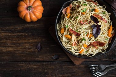 Kabak ve dökme demir tavada pastırma ile sonbahar makarna. Ahşap ev yapımı spagetti kabak makarnaya, kopya alanı. Sonbahar gıda.