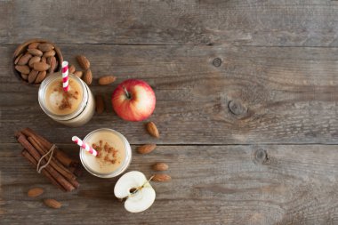 Elmalı turta protein güler yüzlü badem sütü içkiyle. Ahşap zemin, kopya alanı üzerine elmalı turta baharat (Tarçın) ile ev yapımı elma güler yüzlü.