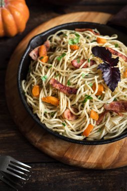 Kabak ve dökme demir tavada pastırma ile sonbahar makarna. Ahşap ev yapımı spagetti kabak makarnaya, kopya alanı. Sonbahar gıda.