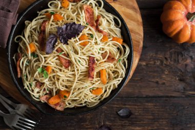 Kabak ve dökme demir tavada pastırma ile sonbahar makarna. Ahşap ev yapımı spagetti kabak makarnaya, kopya alanı. Sonbahar gıda.