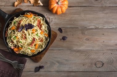 Kabak ve dökme demir tavada pastırma ile sonbahar makarna. Ahşap ev yapımı spagetti kabak makarnaya, kopya alanı. Sonbahar gıda.