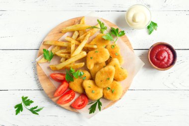 Tavuk nuggets, patates kızartması ve soslar Beyaz ahşap arka planda, yer kopyalayın. Fried nuggets ve ketçap ve mayonez ile patates.