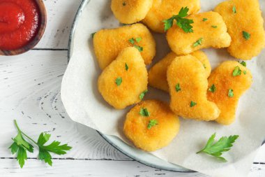 Tavuk nuggets ve beyaz ahşap zemin, kopya alanı üzerine sos. Fried nuggets ketçap ve mayonez ile.