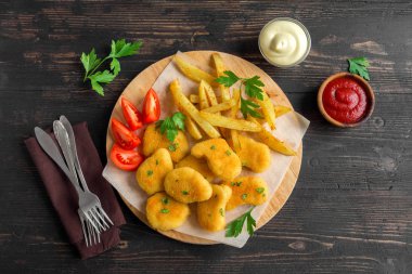 Tavuk nuggets, patates kızartması ve koyu ahşap arka plan üzerinde soslar alanı kopyalayın. Fried nuggets ve ketçap ve mayonez ile patates.