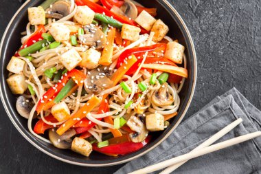 Udon erişte, soya peyniri, mantar ve sebze Fry karıştırın. Asya vegan vejetaryen yemek, yemek, wok siyah arka plan, kopya alanı üzerinde heyecan kızartma.