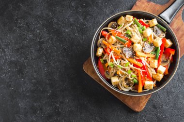 Udon erişte, soya peyniri, mantar ve sebze Fry karıştırın. Asya vegan vejetaryen yemek, yemek, wok siyah arka plan, kopya alanı üzerinde heyecan kızartma.