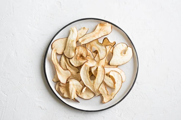 Pear fruit dehydrated chips on white background, copy space, healthy vegan snack.