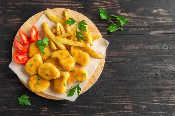 Tavuk nuggets, patates kızartması ve koyu ahşap arka plan üzerinde soslar alanı kopyalayın. Fried nuggets ve ketçap ve mayonez ile patates.