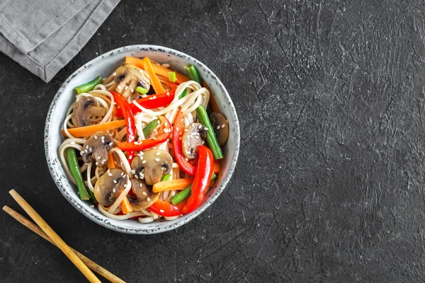 Udon erişte, mantar ve sebze Fry kasede karıştırın. Asya vegan vejetaryen yemek, yemek, stir fry siyah arka plan, kopya alanı üzerinde.