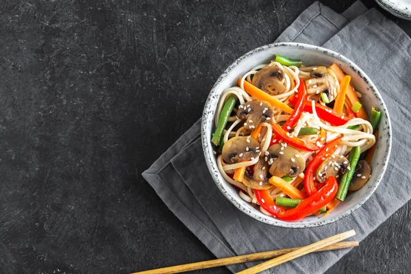 Udon erişte, mantar ve sebze Fry kasede karıştırın. Asya vegan vejetaryen yemek, yemek, stir fry siyah arka plan, kopya alanı üzerinde.