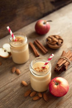 Elmalı turta protein güler yüzlü badem sütü içkiyle. Ahşap zemin, kopya alanı üzerine elmalı turta baharat (Tarçın) ile ev yapımı elma güler yüzlü.