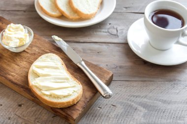 Rustik ahşap arka plan kopya alanı ile kahve fincan ile kahvaltıda ekmek ve tereyağı. Sabah kahvaltı kahve, tereyağı ve tost ile.