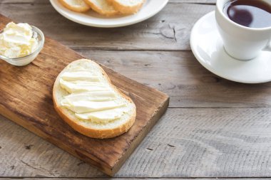 Rustik ahşap arka plan kopya alanı ile üzerinde çay ile kahvaltıda ekmek ve tereyağı. Sabah kahvaltı çay, tereyağı ve tost ile.