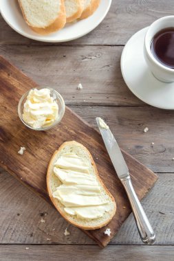 Rustik ahşap arka plan kopya alanı ile kahve fincan ile kahvaltıda ekmek ve tereyağı. Sabah kahvaltı kahve, tereyağı ve tost ile.