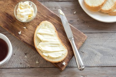 Rustik ahşap arka plan kopya alanı ile üzerinde çay ile kahvaltıda ekmek ve tereyağı. Sabah kahvaltı çay, tereyağı ve tost ile.