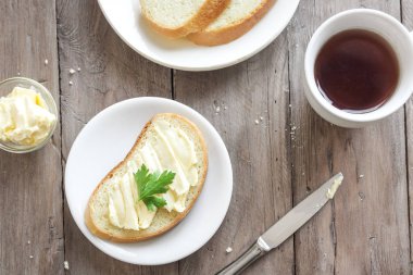 Rustik ahşap arka plan kopya alanı ile üzerinde çay ile kahvaltıda ekmek ve tereyağı. Sabah kahvaltı çay, tereyağı ve tost ile.