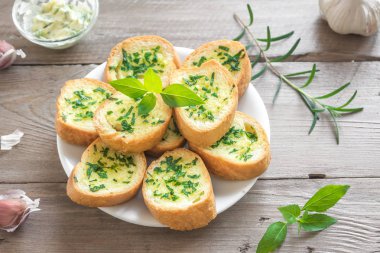 Sarımsak ve malzemelerle ahşap arka plan, kopya alanı üzerinde otlar ile kızarmış ekmek.