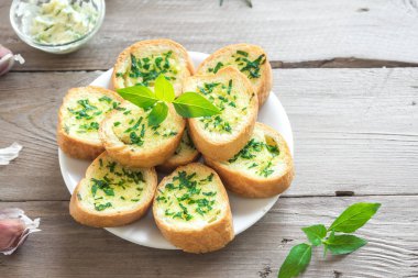 Sarımsak ve malzemelerle ahşap arka plan, kopya alanı üzerinde otlar ile kızarmış ekmek.