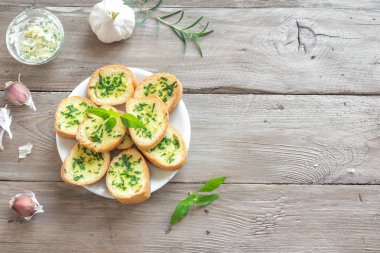 Sarımsak ve malzemelerle ahşap arka plan, kopya alanı üzerinde otlar ile kızarmış ekmek.