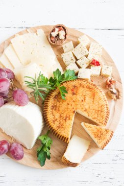 Peynir tabağı ile çeşitli peynirler, üzüm, fındık Beyaz ahşap arka plan, kopya alanı üzerinde. İtalyan peynir ve meyve tabağı.