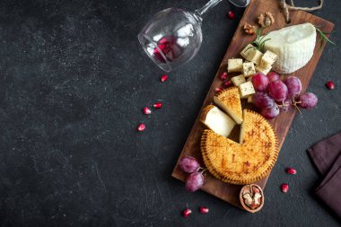 Peynir tabağı ile çeşitli peynirler, üzüm, fındık siyah arka plan, kopya alanı üzerinde. Bal ve şarap ile İtalyan peynir ve meyve tabağı.