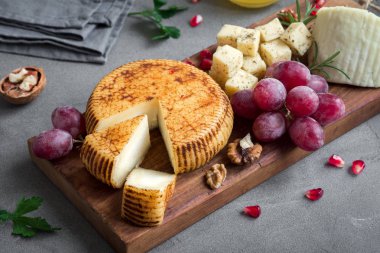 Peynir tabağı ile çeşitli peynirler, üzüm, fındık beton arka plan, kopya alanı üzerinde. Bal ve şarap ile İtalyan peynir ve meyve tabağı.