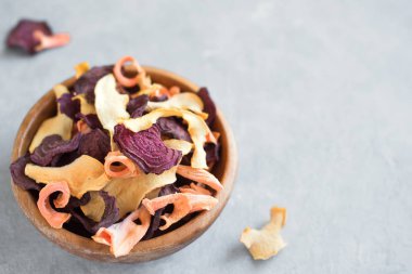 Gri arka plan, kopya alanı üzerinde çeşitli sebze cips. Çeşitli kurutulmuş pancar, havuç, kabak sebze cips - sağlıklı vegan snack.