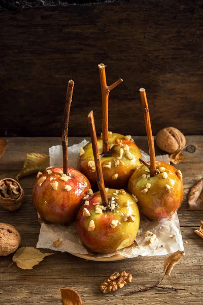 Ev yapımı karamel elmalar Cadılar Bayramı için bir sopa. Organik Snack - karamelli elma ceviz ile.