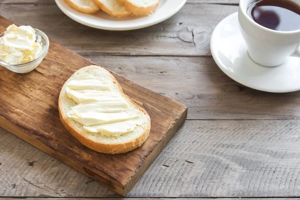 Rustik ahşap arka plan kopya alanı ile üzerinde çay ile kahvaltıda ekmek ve tereyağı. Sabah kahvaltı çay, tereyağı ve tost ile.