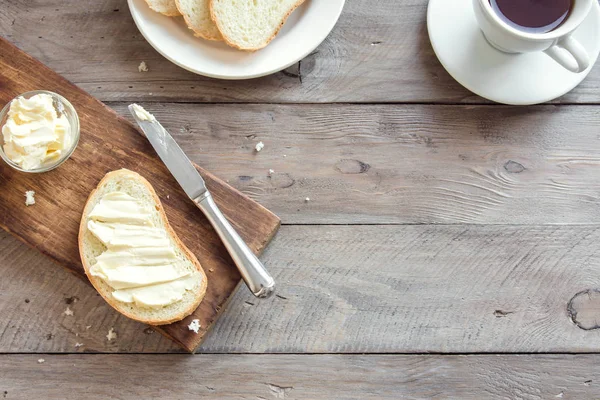 Rustik ahşap arka plan kopya alanı ile kahve fincan ile kahvaltıda ekmek ve tereyağı. Sabah kahvaltı kahve, tereyağı ve tost ile.