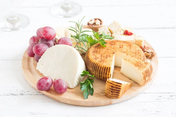 Peynir tabağı ile çeşitli peynirler, üzüm, fındık Beyaz ahşap arka plan, kopya alanı üzerinde. İtalyan peynir ve meyve tabağı.