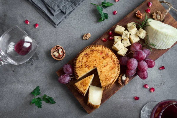 Peynir tabağı ile çeşitli peynirler, üzüm, fındık beton arka plan, kopya alanı üzerinde. Bal ve şarap ile İtalyan peynir ve meyve tabağı.