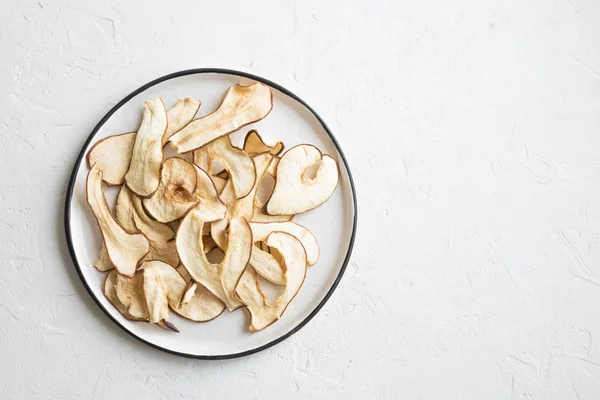 Pear fruit dehydrated chips on white background, copy space, healthy vegan snack.