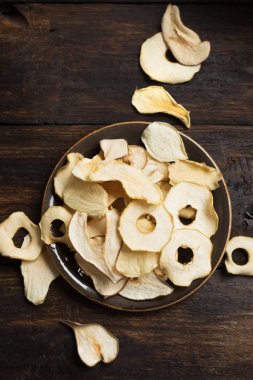 Koyu ahşap arka plan, kopya alanı çeşitli meyve yongaları. Karışık kurutulmuş elma, armut, kavun, mango meyve cips - sağlıklı vegan snack.