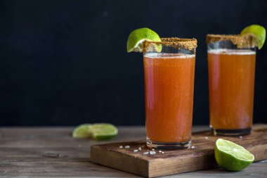Michelada (Meksika kanlı bira) Spisy jant ve domates suyu ile Limes ve Nacho patates kızartması ile servis. Yaz alkol kokteyl Michelada.