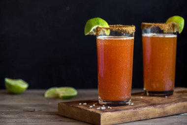 Michelada (Meksika kanlı bira) Spisy jant ve domates suyu ile Limes ve Nacho patates kızartması ile servis. Yaz alkol kokteyl Michelada.
