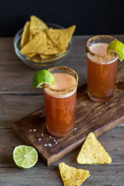 Michelada (Meksika kanlı bira) Spisy jant ve domates suyu ile Limes ve Nacho patates kızartması ile servis. Yaz alkol kokteyl Michelada.