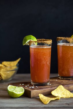 Michelada (Meksika kanlı bira) Spisy jant ve domates suyu ile Limes ve Nacho patates kızartması ile servis. Yaz alkol kokteyl Michelada.