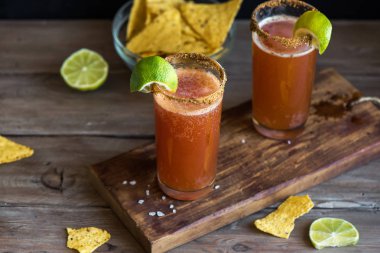 Michelada (Meksika kanlı bira) Spisy jant ve domates suyu ile Limes ve Nacho patates kızartması ile servis. Yaz alkol kokteyl Michelada.