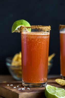 Michelada (Meksika kanlı bira) Spisy jant ve domates suyu ile Limes ve Nacho patates kızartması ile servis. Yaz alkol kokteyl Michelada.