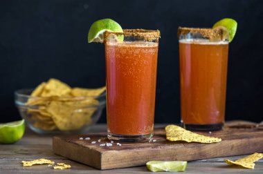 Michelada (Meksika kanlı bira) Spisy jant ve domates suyu ile Limes ve Nacho patates kızartması ile servis. Yaz alkol kokteyl Michelada.