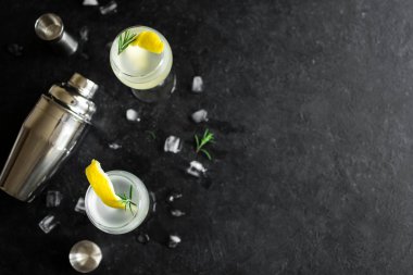 Alkol kokteyl limon, biberiye ve buz ile. Cin tonik fizz veya votka kokteyl siyah arka plan üzerine, kopya alanı.