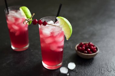 Cape Codder kokteyl kireç ve buz ile. Kızılcık ve votka alkol Cape Codder kokteyl siyah arka plan üzerine.