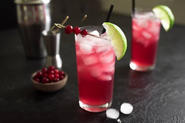 Cape Codder kokteyl kireç ve buz ile. Kızılcık ve votka alkol Cape Codder kokteyl siyah arka plan üzerine.