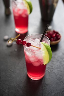 Cape Codder kokteyl kireç ve buz ile. Kızılcık ve votka alkol Cape Codder kokteyl siyah arka plan üzerine.