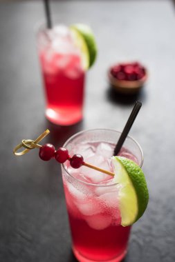 Cape Codder kokteyl kireç ve buz ile. Kızılcık ve votka alkol Cape Codder kokteyl siyah arka plan üzerine.