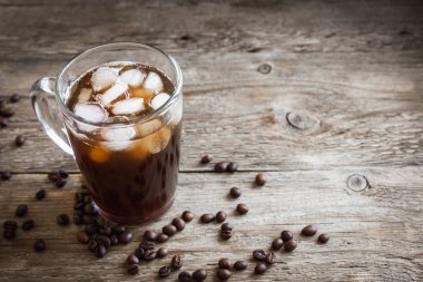 Buzlu kahve ve kahve çekirdekleri rustik ahşap masa, kopya alanı üzerinde. Yenileme buzlu kahve.