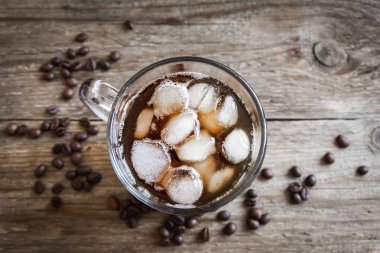 Buzlu kahve ve kahve çekirdekleri rustik ahşap masa, kopya alanı üzerinde. Yenileme buzlu kahve.